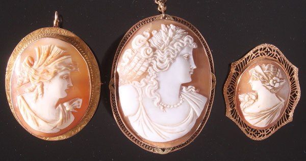THREE VICTORIAN CARVED SHELL CAMEOS.: THREE VICTORIAN CARVED SHELL CAMEOS. Comprising a pendant in gold filled bezel, a 10K gold filigree mount pin and a 10K gold bezel mount pendant/pin. Largest 1.75 inches x 1.25 inches (45 x 32 mm).
