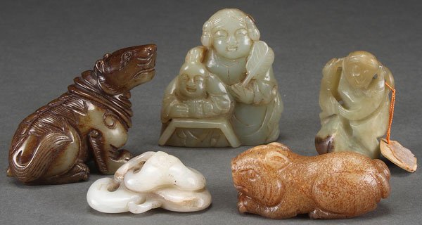 FIVE CHINESE CARVED JADE ORNAMENTS: FIVE CHINESE CARVED JADE ORNAMENTS. Comprising two archaic style mythical beasts, a white jade fungus, a monkey, and a pair of figures. The largest height 2.5 inches (6 cm).