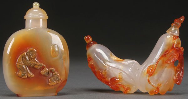 TWO CHINESE CARVED CARNELIAN AGATE SNUFF BOTTLES: TWO CHINESE CARVED CARNELIAN AGATE SNUFF BOTTLES. Comprising a double bottle "Buddha's Hand" with dragonette and a flattened ovoid with figure. Each well hollowed. The largest 3.5 inches (9 cm).