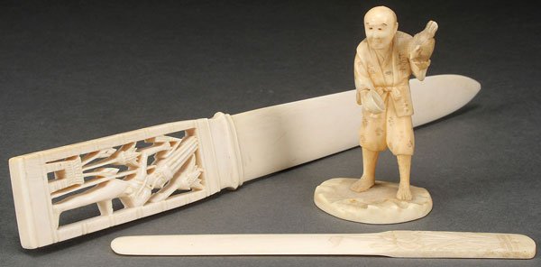 A THREE PIECE CARVED IVORY GROUP: A THREE PIECE CARVED IVORY GROUP, PROBABLY CIRCA 1900. Comprising a Japanese Okimono of a man feeding a chicken. A pierced handle paper knife with erotic Egyptian motif and a Japanese paper knife with