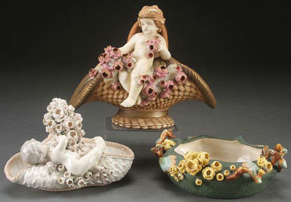 THREE PIECE GROUP OF AUSTRIAN AMPHORA ART POTTERY: THREE PIECE GROUP OF AUSTRIAN AMPHORA ART POTTERY, EARLY 20TH CENTURY. Comprising two basket forms with putto and encrusted with floral blossoms, and a similar decorated handled low bowl. The largest