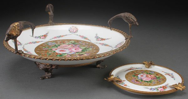 A LIMOGÉS PORCELAIN AND GILT BRONZE MOUNTED: A LIMOGÉS PORCELAIN AND GILT BRONZE MOUNTED COUP, FIRST HALF 20TH CENTURY. The porcelain coup decorated with transfer floral garlands, the cavetto with gilt reserve and mounted with a gilt bronze rim