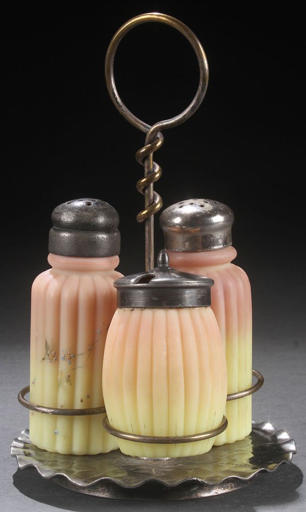 A MT. WASHINGTON BURMESE ART GLASS CONDIMENT SET: A MT. WASHINGTON BURMESE ART GLASS CONDIMENT SET, LATE 19TH CENTURY. Comprising two ribbed shakers, one with enameled florals and a ribbed covered mustard. Contained in a Pairpoint silvered frame. Hei