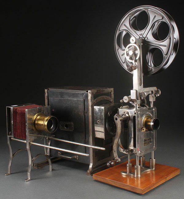 POWERS 35MM MODEL FIVE HAND CRANKED MOTION PICTUR: POWERS 35MM MODEL FIVE HAND CRANKED MOTION PICTURE PROJECTION HEAD, CIRCA 1906. Mounted on wooden base, used to project silent motion pictures in a theater, includes feed reel, together with a Selig p