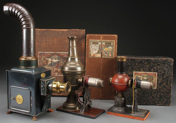 THREE 19TH CENTURY MAGIC LANTERNS IN ORIGINAL BOX: THREE 19TH CENTURY MAGIC LANTERNS IN ORIGINAL BOXES. Comprising two Ernst Plank including gloria and a Jean Schoenner, the largest 16.75 inches (42.5 cm). And contained in original wood cases with pap