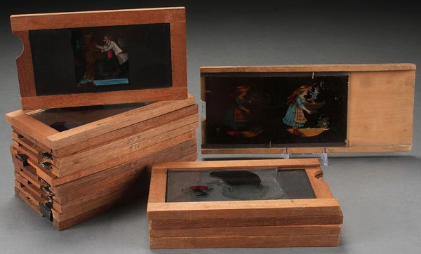 FOURTEEN MCALLISTER MAGIC LANTERN SLIPPING SLIDES: FOURTEEN MCALLISTER MAGIC LANTERN SLIPPING SLIDES, LATE 19TH CENTURY. Hand-colored and wood framed of humorous subjects together with a German sliding slide and an "Adieu" funerary slide. Most 7 inch