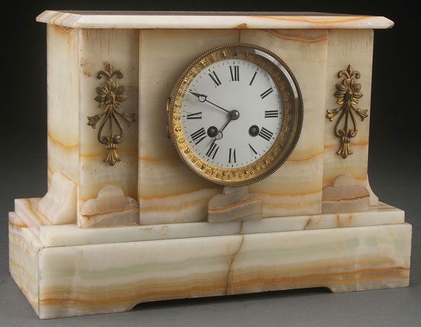 A FRENCH ONYX AND GILT BRONZE MANTLE CLOCK: A FRENCH ONYX AND GILT BRONZE MANTLE CLOCK, CIRCA 1900. Of architectural form with gilt floral mounts and embossed gilt bezel. Length 13.5 inches (34 cm).