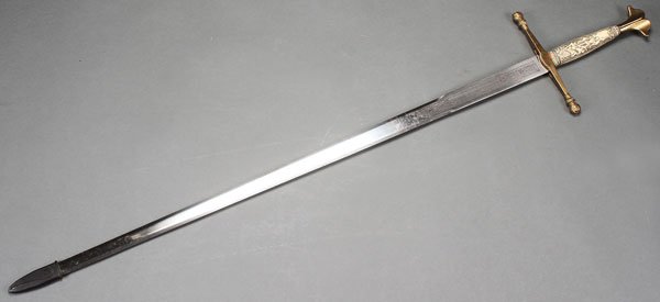 A LARGE AND IMPRESSIVE SWORD TOLEDO, SPAIN, SECON: A LARGE AND IMPRESSIVE SWORD TOLEDO, SPAIN, SECOND HALF OF THE 20TH CENTURY IN THE 15TH CENTURY STYLE. The double edged blade etched, the cross guard with figural heads on terminating ends and with fa