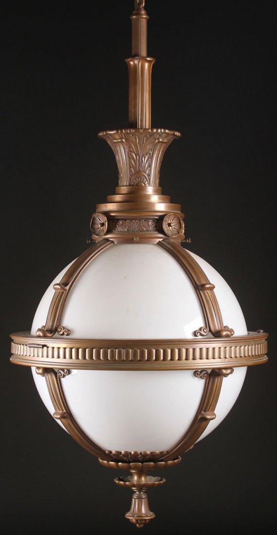 A MATCHING PAIR OF LARGE BRONZE AND OPAL GLASS: A MATCHING PAIR OF LARGE BRONZE AND OPAL GLASS HANGING PENDANT LIGHT FIXTURES, EARLY 20TH CENTURY. Of spherical form, with bronze brackets embossed with extending scrolls and stylized acanthus. Probab