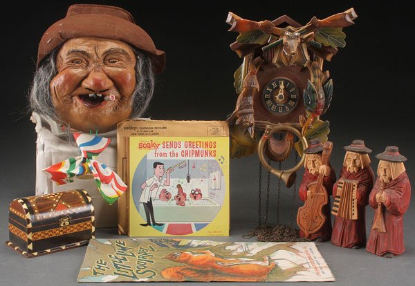 A MID-CENTURY NOVELTY AND COLLECTABLES GROUP: A MID-CENTURY NOVELTY AND COLLECTABLES GROUP. Comprising a Laffun head drunkard in original box, a carved wood German cuckoo clock, carved wood and polychrome musician figures, a parquetry dresser box