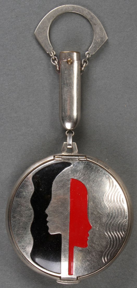 A RICHARD HUDNUT FOR DEAUVILLE ART DECO COMPACT: A RICHARD HUDNUT FOR DEAUVILLE ART DECO COMPACT, CIRCA 1925. Of pendant form with enameled profiles suspended from a lipstick holder. Contained in the original fitted box. Length 5 inches (13 cm) and 