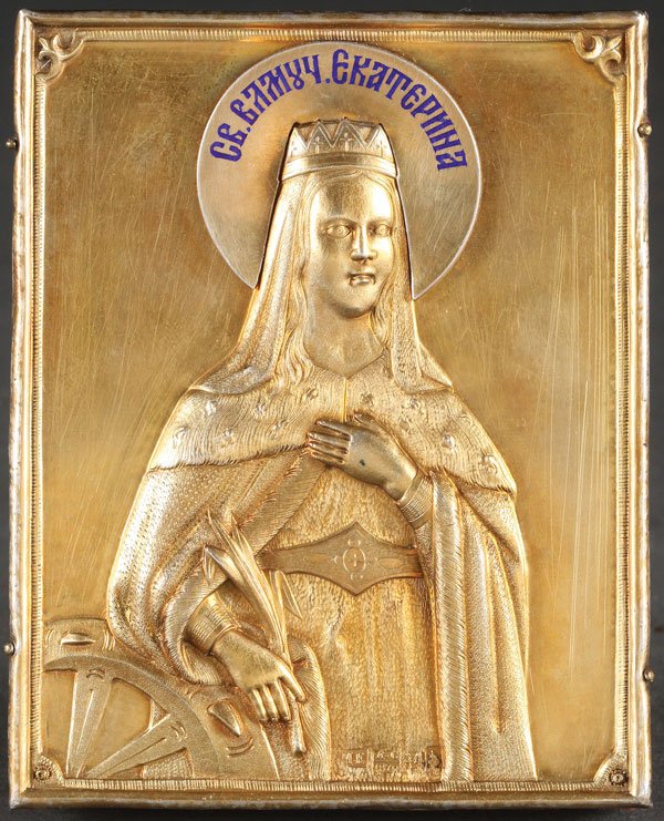 AN INTERESTING RUSSIAN ICON OF ST. CATHERINE: AN INTERESTING RUSSIAN ICON OF ST. CATHERINE, MOSCOW, 1870. Finely executed in silver-gilt and chased repoussé. Depicted in royal attire with crown holding a martyr's palm and next to the implement