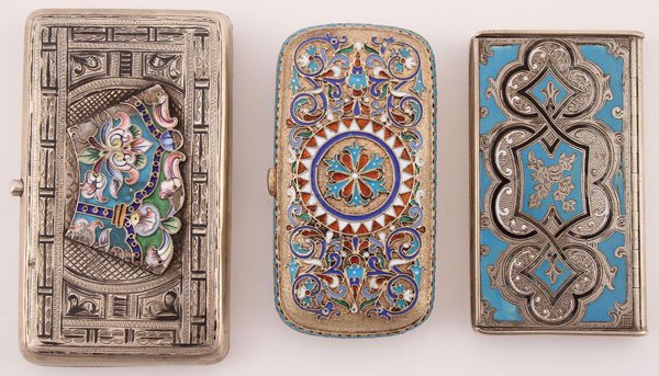 THREE SILVER AND ENAMELED CASES, CIRCA 1850-1908: THREE SILVER AND ENAMELED CASES, CIRCA 1850-1908. Comprising a Russian silver-nielloed and enameled cigarette case. The front and back of the hinged lid engraved and neilloed and set with champleve an