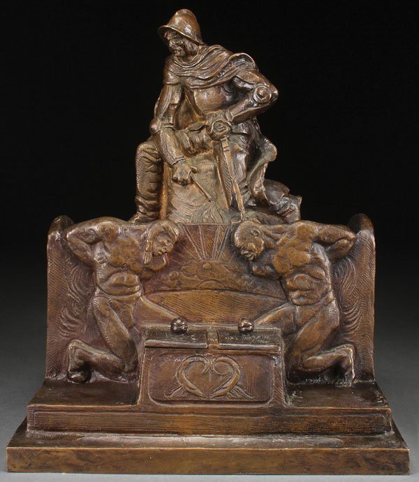 A BRONZE SCULPTURAL DESK SET, AMERICAN ART: A BRONZE SCULPTURAL DESK SET, AMERICAN ART FOUNDRY NEW YORK, CIRCA 1915. At top is depicted a Spanish Conquistador in armor holding a whip, and beneath him an enslaved Native American (left) and an Af