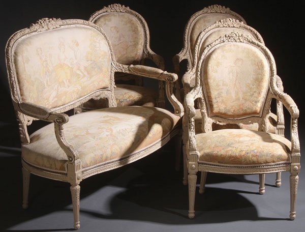 LOUIS XVI STYLE CREAM PAINTED PARLOR SET: A FIVE PIECE LOUIS XVI STYLE CREAM PAINTED PARLOR SUITE, EARLY 20TH CENTURY. Comprising a settee and four side chairs, each with deeply carved wooden frames and tapestry woven pictorial coverings, the