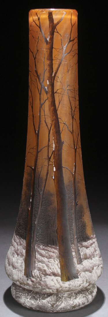 A DAUM NANCY ENAMELED CAMEO “WINTER SCENE” GLASS VASE: A DAUM NANCY FRENCH ENAMELED CAMEO “WINTER SCENE” ART GLASS VASE, EARLY 20TH CENTURY. Of tapering cylindrical form internally decorated with gray and amber glass. Cut with a design of barren tree