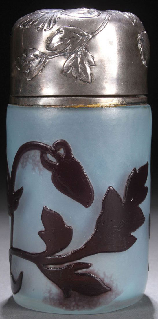 A DAUM NANCY CAMEO GLASS & SILVER DRESSER JAR: A DAUM NANCY FRENCH CAMEO GLASS AND SILVER DRESSER JAR, CIRCA 1900. In opalescent glass with pale blue overtones overlaid in amethyst and wheel carved with a design of flowering iris, surmounted with