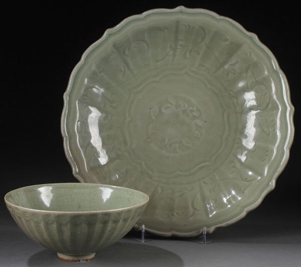 TWO LONGQUAN CELADON GLAZED CERAMIC DISHES: TWO LONGQUAN CELADON GLAZED CERAMIC DISHES, PROBABLY MING DYNASTY OR PERHAPS EARLIER. Comprising a lotus bowl with a fine crackle glaze and raised on a short foot rim, and a barbed rim charger carved 