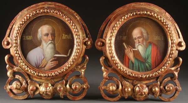 A PAIR OF RUSSIAN ICONS DEPICTING THE EVANGELISTS: A PAIR OF RUSSIAN ICONS DEPICTING THE EVANGELISTS, MATTHEW AND JOHN, CIRCA 1800. Each painted in the round and set within integral carved gilt wood frames, suggesting that these were once part of a fo