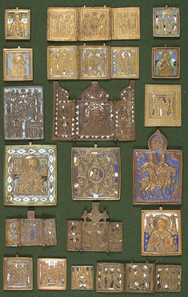 A GROUP OF 19 RUSSIAN CAST BRASS AND COPPER ICONS: A GROUP OF 19 RUSSIAN CAST BRASS AND COPPER ICONS, CIRCA 1780-1880. Including triptychs and individual icons. All except one with champlevé enamel decoration including some scarce color variations. M