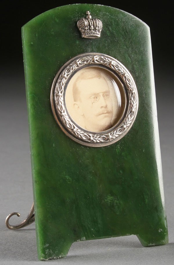 A RUSSIAN-STYLE NEPHRITE PICTURE FRAME: A RUSSIAN-STYLE NEPHRITE PICTURE FRAME, SECOND HALF OF THE 20TH CENTURY. With silver laurel-leaf circular bezel beneath an Imperial Crown and with spurious maker's marks and hallmarks. Height 4.3 inch