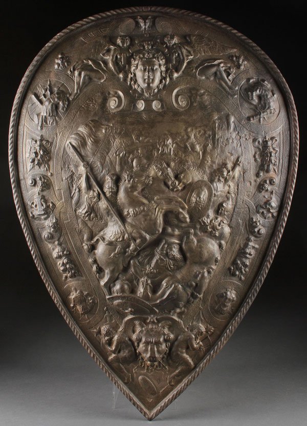 A VICTORIAN NEO CLASSIC CAST IRON SHIELD: A VICTORIAN NEO CLASSIC CAST IRON SHIELD. Deeply embossed with Greek warriors, armor and figures. Height 25.25 inches.