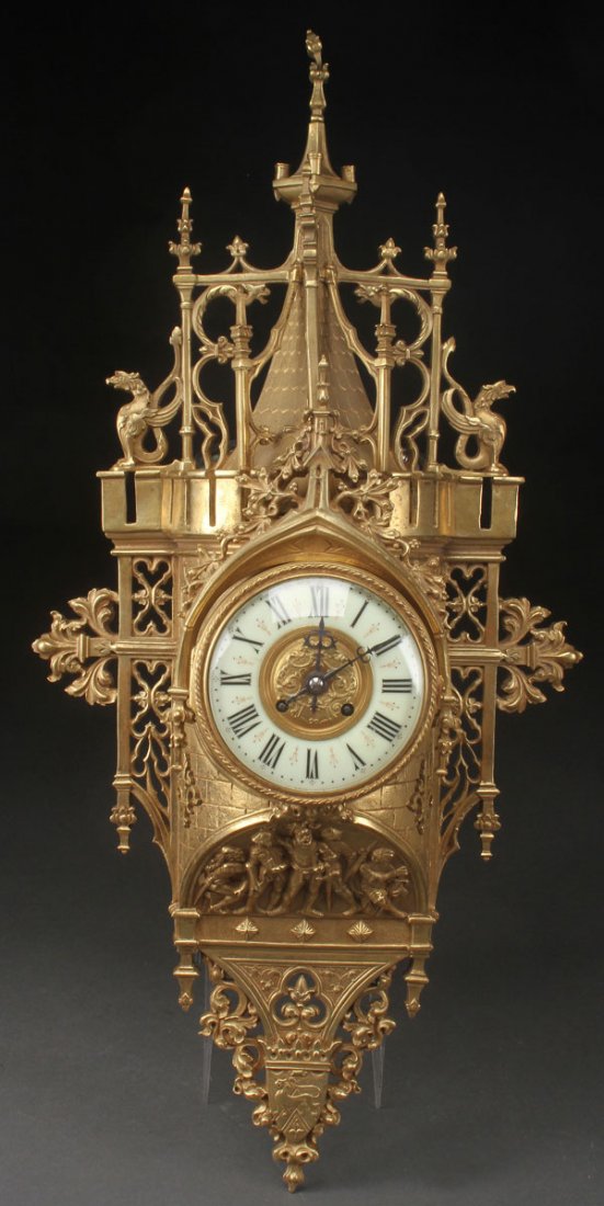 FRENCH GOTHIC REVIVAL GILT BRONZE WALL CLOCK: A FINE FRENCH GOTHIC REVIVAL GILT BRONZE WALL CLOCK, 19TH CENTURY. Modelled as a medieval castle turret with extending open work brackets and an arched panel depicting five knights in armor. The casti