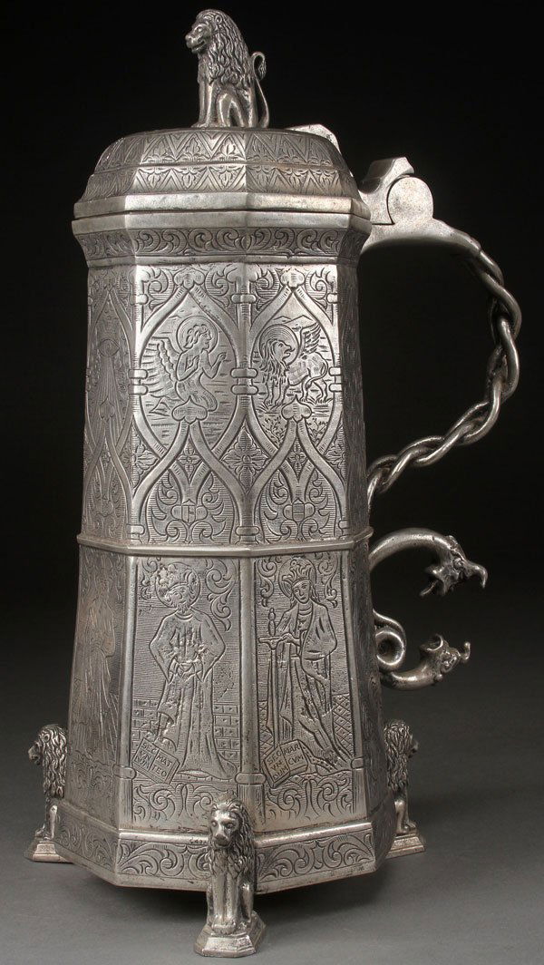 A MONUMENTAL GOTHIC STYLE PEWTER TANKARD, 20TH C.: A MONUMENTAL GOTHIC STYLE PEWTER TANKARD, 20TH CENTURY. Of tapering hexagonal form, the panels incised all over with the full figures of Saints, scrolled foliates, and strap work raised on three figur