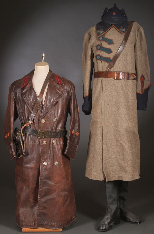 A RUSSIAN SOVIET UNIFORM GROUPING: A RUSSIAN SOVIET UNIFORM GROUPING, POSSIBLY SECOND HALF OF 20TH CENTURY (?). Comprising of a long leather trench coat, exhibiting the insignia of the NKVD with period leather belt and with leather Nag