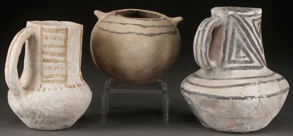 RESERVE BLACK ON WHITE POTTERY JUGS: THREE PRE HISTORIC RESERVE BLACK ON WHITE POTTERY JUGS, MOGOLLON, A.D. 1100-1200. Two with applied handles and one with suspension mounts on shoulder. Some restorations. The largest height 6.5 inches.
