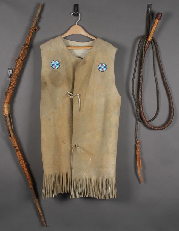 A NATIVE AMERICAN STYLE BEADED LEATHER LONG VEST: A NATIVE AMERICAN STYLE BEADED LEATHER LONG VEST. Contemporary, the breast panels with two beaded rosettes, the back with two mohair drop hangs, together with a Native American sinew wrapped wooden bo