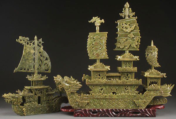 A PAIR OF ORIENTAL CARVED STONE DRAGON BOATS: A PAIR OF ORIENTAL CARVED STONE DRAGON BOATS, 20TH CENTURY. Each carved in spinach green colored serpentine in the form of boats with dragon head bows, multi-tiered pagodas and sails. Some damage and
