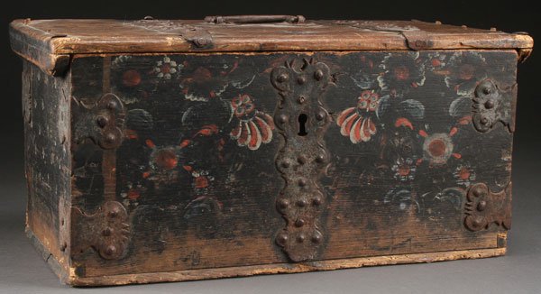 A NORWEGIAN FOLK ART DECORATED SMALL TRAVEL TRUNK: A NORWEGIAN FOLK ART DECORATED SMALL TRAVEL TRUNK, EARLY TO MID 19TH CENTURY. The carved flat panel top with riveted iron strap work above a front panel decorated with telemark style florals and cut i
