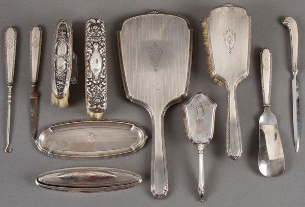 A STERLING SILVER DRESSER SET, EARLY 20TH CENTURY: A STERLING SILVER DRESSER SET, EARLY 20TH CENTURY. Eight pieces comprising a hand mirror, hairbrush, shoe horn, button hook, nail file, nail buff and rest, and oval pin tray. Together with a similar
