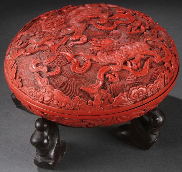 FINE CHINESE CARVED CINNABAR BOX: A VERY FINE CHINESE CARVED CINNABAR COVERED BOX. The bottom section well carved all over with scene of a water dragon, fish and various Buddhist attributes below a cover carved in deep relief with two