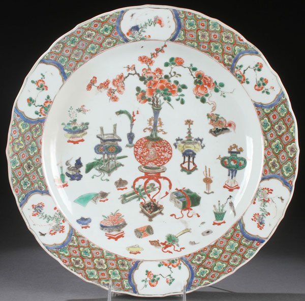 CHINESE FAMILLE VERTE CHARGER, C. 1700: A CHINESE KANGXI FAMILLE VERTE PORCELAIN CHARGER, CIRCA 1700. Of round form with slightly dished interior, decorated with floral still lifes and Buddhist symbols within a wide flaring rim with six sce