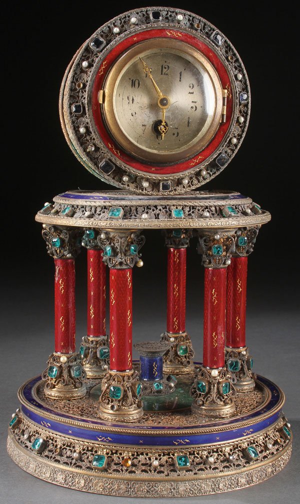 GILT, JEWELED, & ENAMEL ARCHITECTURAL CLOCK: AN INTERESTING GILT FILIGREE, JEWELED, AND ENAMEL ARCHITECTURAL CLOCK, CIRCA 1900, FRENCH OR AUSTRIAN. Of Neo-Classic form modeled as a rotunda, the six translucent rouge enameled columns with jewel