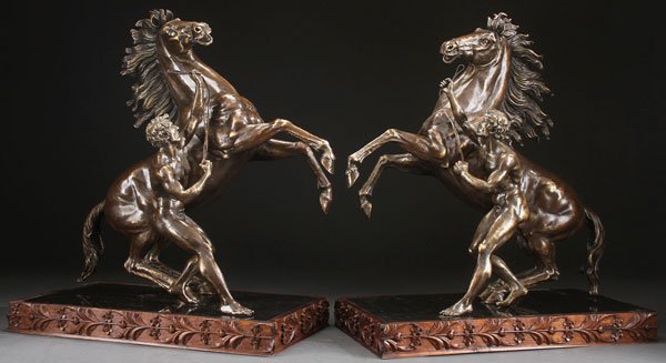PAIR OF BRONZE MARLEY HORSES AFTER COUSTEAU: After GUILLAME COUSTOU (French 1677-1746) A Pair of Marley Horses Bronze with parcel gilt and light brown patina, each raised on black marble stands contained within a foliate carved walnut surround H