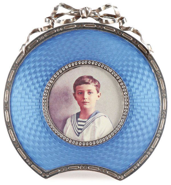 A RUSSIAN SILVER, ENAMEL PICTURE FRAME: A RUSSIAN SILVER AND TRANSLUCENT ENAMEL PICTURE FRAME, ST. PETERSBURG, CIRCA 1900. The frame of partial circular form with translucent blue enamel over a guilloche basketweave ground, the outer border