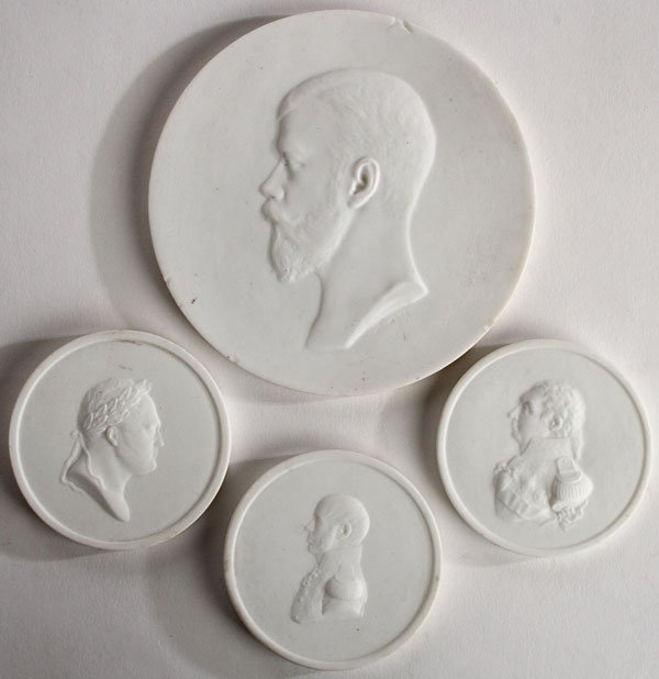 4 RUSSIAN IMPERIAL PORCELAIN FACTORY PLAQUES: A GROUP OF FOUR RUSSIAN IMPERIAL PORCELAIN FACTORY BISQUE PORCELAIN CIRCULAR BAS RELIEF PLAQUES, PERIOD OF TSAR NICHOLAS II. Comprising a bust portrait of Tsar Nicholas II, verso with mark of Nicholas