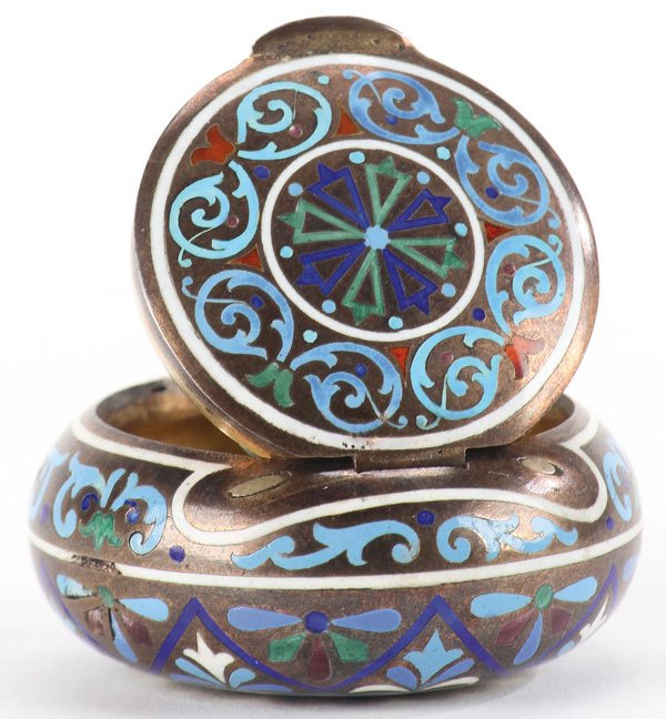 A RUSSIAN SILVER GILT & ENAMEL PILL BOX C. 1890: A RUSSIAN SILVER GILT AND CHAMPLEVE PILL BOX, ST. PETERSBURG, CIRCA 1890. The compressed spherical form enameled overall with medallions and scrolling foliage. The hinged lid with overhanging thumb pi