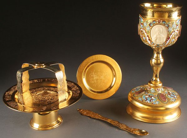 A RUSSIAN GILT AND ENAMEL COMMUNION SET.: A RUSSIAN GILT AND ENAMEL COMMUNION SET. Comprising a large and impressive gilt metal chalice profusely decorated with cloisonne enamel and the cup set with two finely carved ivory medallion icons, on