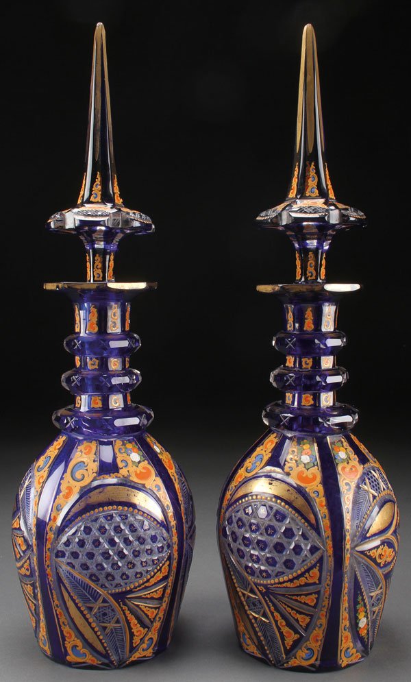 A PAIR OF BOHEMIAN CUT AND ENAMELED GLASS BOTTLES: A PAIR OF BOHEMIAN CUT AND ENAMELED GLASS BOTTLES FOR THE PERSIAN/TURKISH MARKET, 19TH CENTURY. Each of pear shaped bottle form with three applied ring handles and overlaid with cobalt blue and cut w