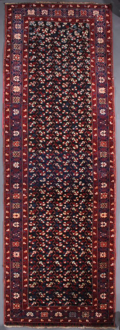 A CAUCASIAN ARMENIAN KAZAK ORIENTAL RUNNER: A CAUCASIAN ARMENIAN KAZAK ORIENTAL RUNNER, SECOND QUARTER 20TH CENTURY. With inscription in top border panel. 3 feet 6 inches x 10 feet 6 inches (106.6 x 320 cm). Provenance: From the lifetime estate