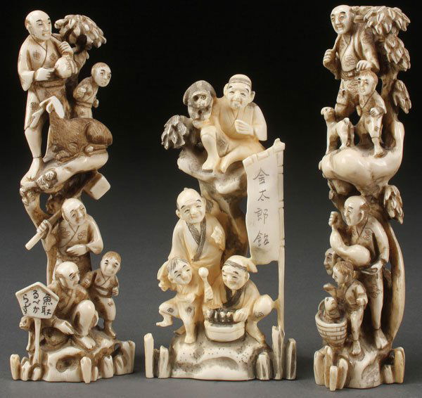 A GROUP OF THREE JAPANESE CARVED IVORY ORNAMENTS: A GROUP OF THREE JAPANESE CARVED IVORY ORNAMENTS, MEIJI PERIOD. Comprising a pair of pillared scenes each depicting five figures in various activities and a group of four figures with one displaying a