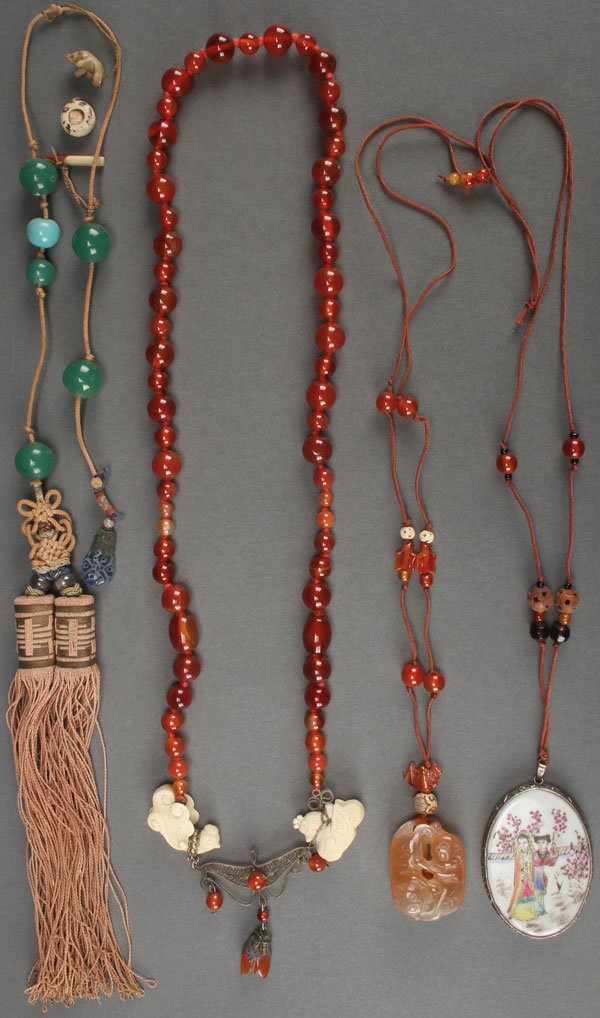 A GROUP OF FOUR CHINESE NECKLACES AND ORNAMENTS: A GROUP OF FOUR CHINESE NECKLACES AND ORNAMENTS, 19TH/20TH CENTURY. The first strung with green jade colored glass beads and with two tassels joined with an endless knot, the second comprised of carve