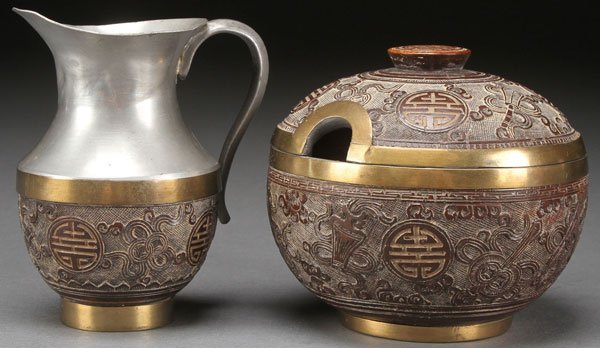CHINESE CARVED BROWN LACQUER CREAM AND SUGAR: A VERY FINE CHINESE CARVED BROWN LACQUER CREAM AND SUGAR, CIRCA 1900. With Buddhist designs in relief, embossed seal mark on base. Height 4 inches (10 cm).