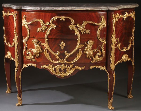 LOUIS XV STYLE GILT BRONZE COMMODE: A LOUIS XV STYLE GILT BRONZE AND MARBLE TOPPED MAHOGANY COMMODE, 20TH CENTURY. In the manner of Charles Cressent. The two drawer bow front mounted with putti and elaborately scrolled acanthus, scallop