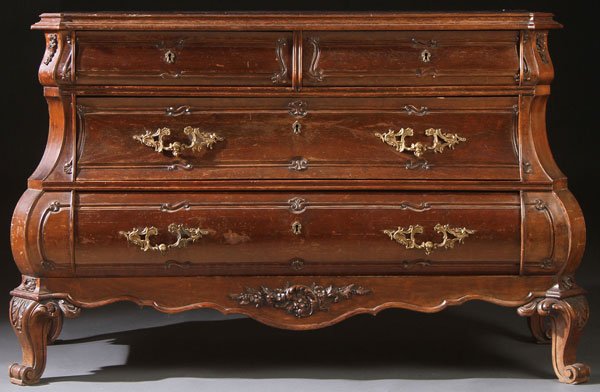 A FRENCH PROVINCIAL ROCOCO REVIVAL WALNUT COMMODE: A FRENCH PROVINCIAL ROCOCO REVIVAL WALNUT COMMODE, 20TH CENTURY. Of Bombay form with four drawers, carved with finger mold scrolled brackets and foliates in relief. The lower two drawers mounted with 