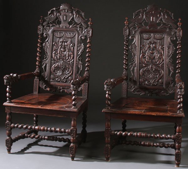 PAIR OF NORTHERN ITALIAN GOTHIC REVIVAL ARMCHAIRS: A FINE PAIR OF NORTHERN ITALIAN GOTHIC REVIVAL CARVED OAK ARMCHAIRS, CIRCA 1900. The elongated back panels carved in relief with facial masks, scrolled acanthus and rosettes, below an openwork crest o